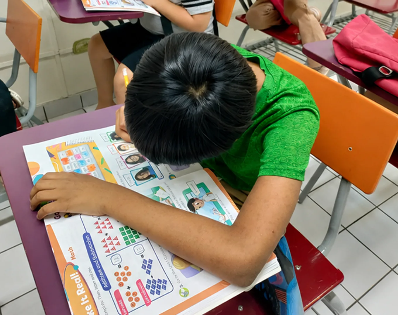 Niño trabajando en su libro de inglés en clase